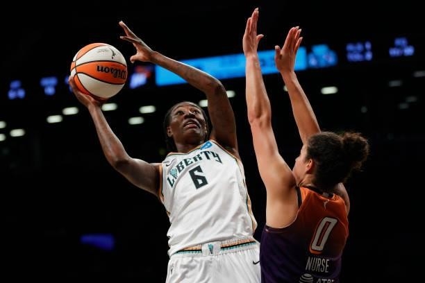 Natasha Howard of the New York Liberty goes to the basket as Kia Nurse of the Phoenix Mercury defends during the first half at Barclays Center on...