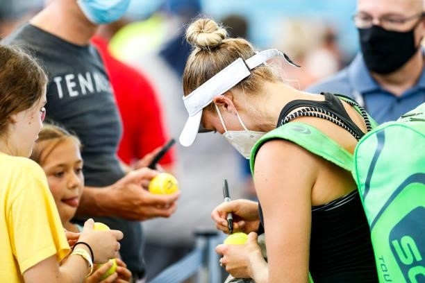 Catherine Harrison of USA signs autographs after winning her quarterfinal doubles match against Elixane Lechemia of France and Ingrid Neel of USA on...