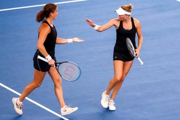 Ulrikke Eikeri of Norway and Catherine Harrison of USA high five during the first set of their doubles match against Elixane Lechemia of France and...
