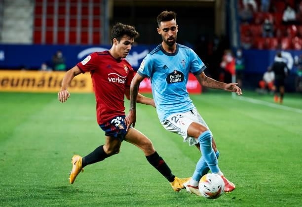Brais Mendez of Celta de Vigo duels for the ball with Manu Sanchez of CA Osasuna during the La Liga Santader match between CA Osasuna and RC Celta de...