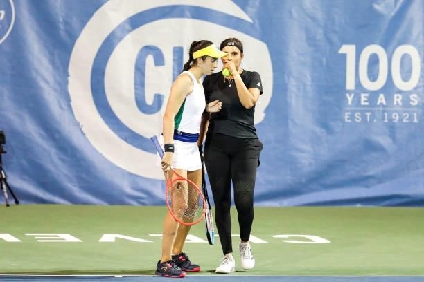 Christina McHale of USA and Sania Mirza of India whisper to each other during the second set of their quarterfinal doubles match against Shuai Zhang...
