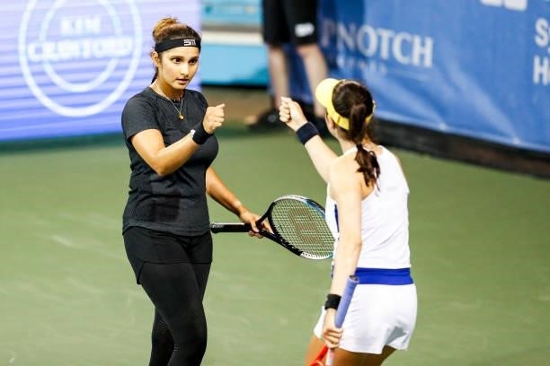 Sania Mirza of India and Christina McHale of USA fist bump during the first set of their quarterfinal doubles match against Shuai Zhang of China and...