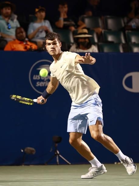 Carlos Alcaraz of Spain returns a shot to Marcos Giron in the quarterfinals of the Winston-Salem Open at Wake Forest Tennis Complex on August 26,...