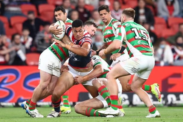 Tuku Hau Tapuha of the Roosters is tackled during the round 24 NRL match between the Sydney Roosters and the South Sydney Rabbitohs at Suncorp...