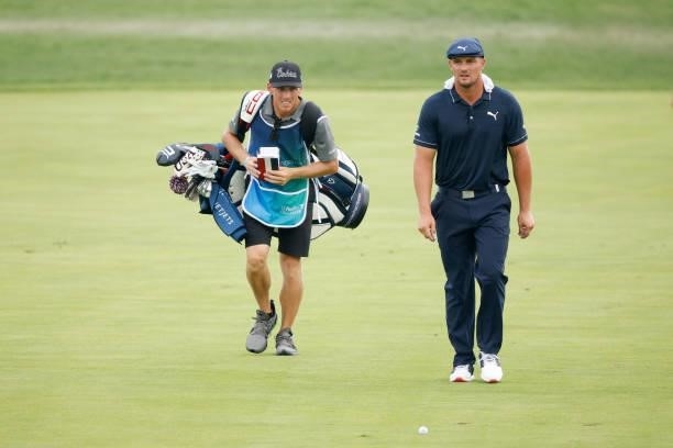 Bryson DeChambeau of the United States reacts as he walks up the 18th fairway with his caddie Brian Zeigler during the second round of the BMW...