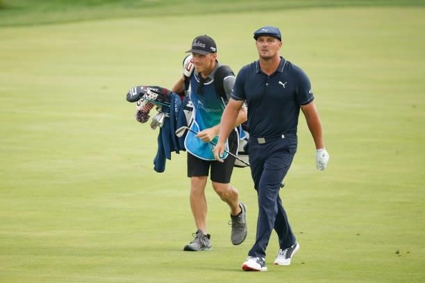 Bryson DeChambeau of the United States reacts as he walks up the 18th fairway with his caddie Brian Zeigler during the second round of the BMW...