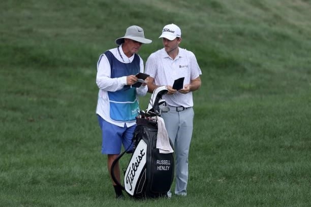 Russell Henley of the United States talks with his caddie on the seventh hole during the second round of the BMW Championship at Caves Valley Golf...