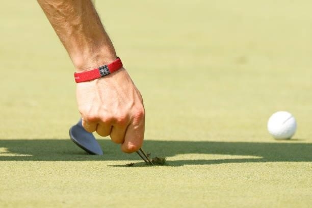 Justin Thomas of the United States repairs a divot mark during the second round of the BMW Championship at Caves Valley Golf Club on August 27, 2021...