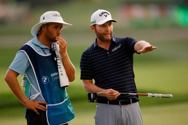 Branden Grace of South Africa talks with his caddie Lee Warne on the 18th green during the second round of the BMW Championship at Caves Valley Golf...