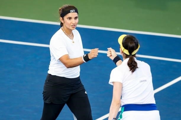Sania Mirza of India fist bumps Christina McHale of the United States during the first set of their semifinal doubles match against Ulrikke Eikeri of...