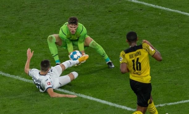 Goalkeeper Gregor Kobel of Borussia Dortmund is tackled by Mijat Gacinovic of TSG Hoffenheim during the Bundesliga match between Borussia Dortmund...