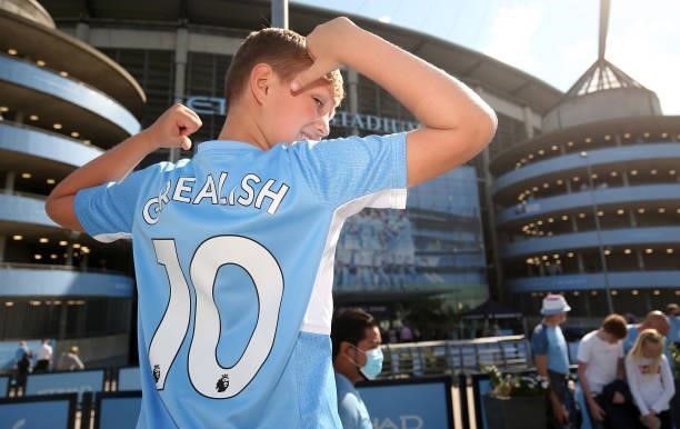 Fan poses outside the stadium wearing a shirt with 'Grealish' on the back prior to the Premier League match between Manchester City and Arsenal at...