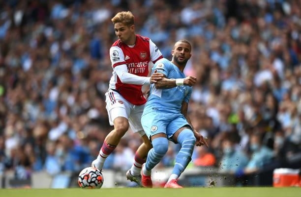 Emile Smith Rowe of Arsenal is challenged by Kyle Walker of Manchester City during the Premier League match between Manchester City and Arsenal at...