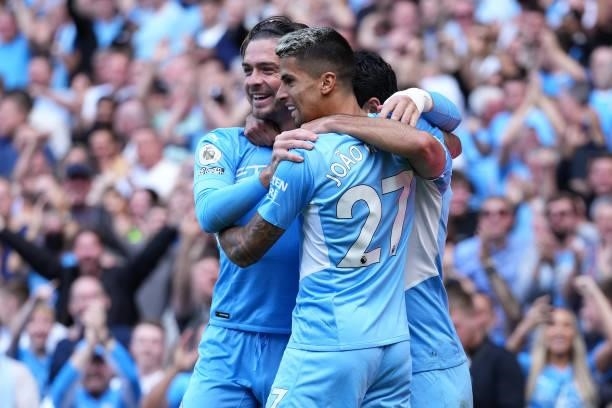 Ilkay Gundogan of Manchester City celebrates with teammates Jack Grealish and Joao Cancelo after scoring his team's first goal during the Premier...