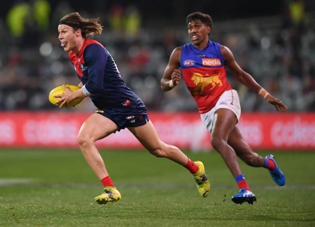 Ed Langdon of the Demons gets away from Keidean Coleman of the Lions during the AFL First Qualifying Final match between Melbourne Demons and...