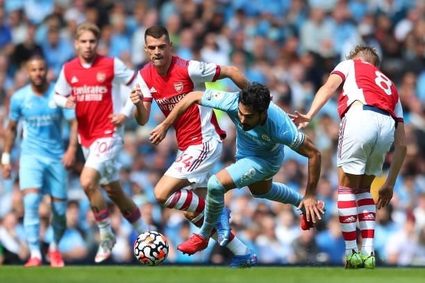 Ilkay Gundogan of Manchester City is challenged by Granit Xhaka and Martin Odegaard of Arsenal during the Premier League match between Manchester...