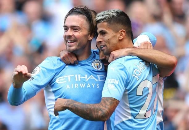 Ilkay Gundogan of Manchester City celebrates with teammates Jack Grealish and Joao Cancelo after scoring his team's first goal during the Premier...