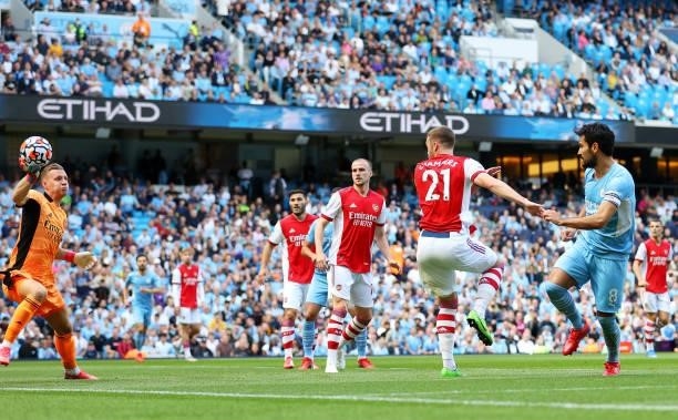 Ilkay Gundogan of Manchester City scores his team's first goal past Bernd Leno of Arsenal during the Premier League match between Manchester City and...