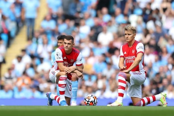 Granit Xhaka and Martin Odegaard of Arsenal take a knee in support of the Black Lives Matter Movement prior to during the Premier League match...