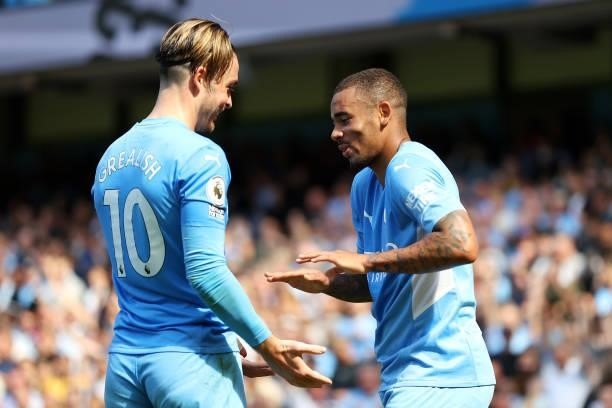 Gabriel Jesus of Manchester City celebrates after scoring their sides third goal with team mate Jack Grealish during the Premier League match between...