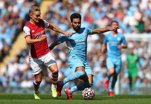 Martin Odegaard of Arsenal battles for possession with Ilkay Gundogan of Manchester City during the Premier League match between Manchester City and...