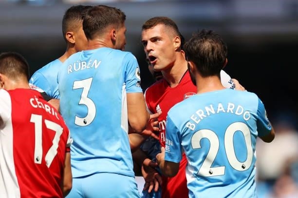 Granit Xhaka of Arsenal clashes with Ruben Dias of Manchester City during the Premier League match between Manchester City and Arsenal at Etihad...