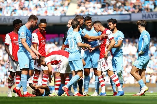 Granit Xhaka of Arsenal clashes with Bernardo Silva and Ruben Dias of Manchester City after receiving a red card during the Premier League match...