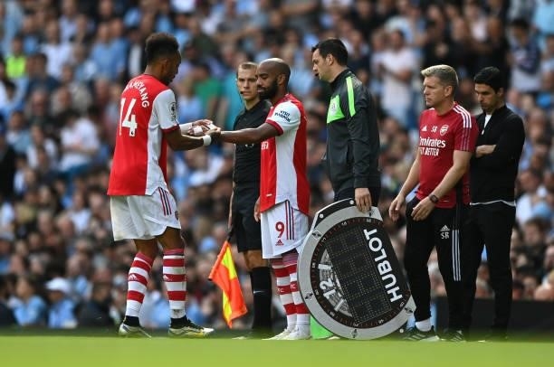 Pierre-Emerick Aubameyang of Arsenal hands over the armband to team mate Alexandre Lacazette during the Premier League match between Manchester City...