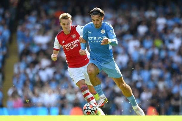 Jack Grealish of Manchester City battles for possession with Martin Odegaard of Arsenal during the Premier League match between Manchester City and...