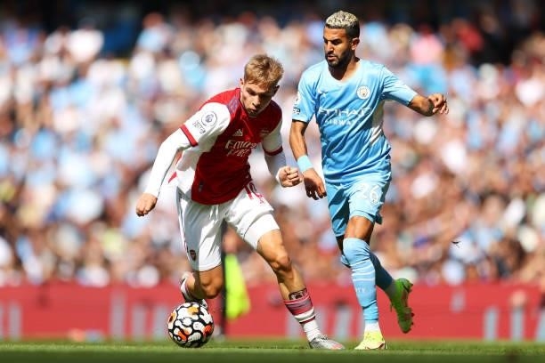 Emile Smith Rowe of Arsenal is challenged by Riyad Mahrez of Manchester City during the Premier League match between Manchester City and Arsenal at...
