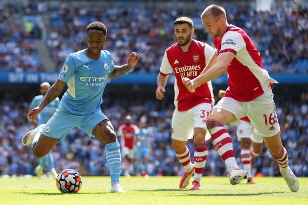 Raheem Sterling of Manchester City battles for possession with Rob Holding of Arsenal during the Premier League match between Manchester City and...