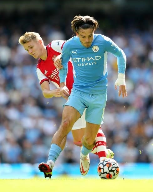 Jack Grealish of Manchester City battles for possession with Martin Odegaard of Arsenal during the Premier League match between Manchester City and...