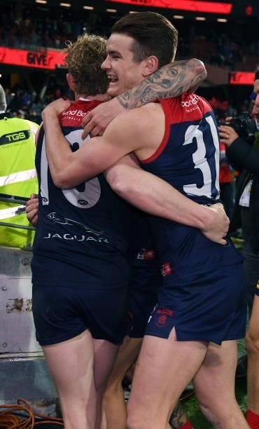 Clayton Oliver of the Demons and Bayley Frisch of the Demons hug as they head down the race after winning the AFL First Qualifying Final match...