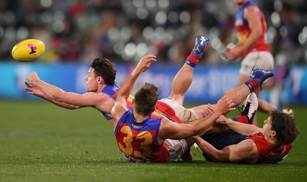 Lachie Neale of the Lions handballs over Zac Bailey of the Lions and during the AFL First Qualifying Final match between Melbourne Demons and...