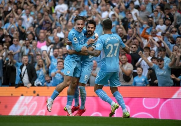 Ilkay Gündogan of Manchester City celebrates scoring the first goal with team mates Jack Grealish and João Cancelo during the Premier League match...