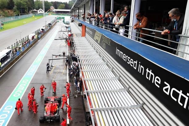 Fans look on as Carlos Sainz of Spain driving the Scuderia Ferrari SF21 stops in the Pitlane during qualifying ahead of the F1 Grand Prix of Belgium...