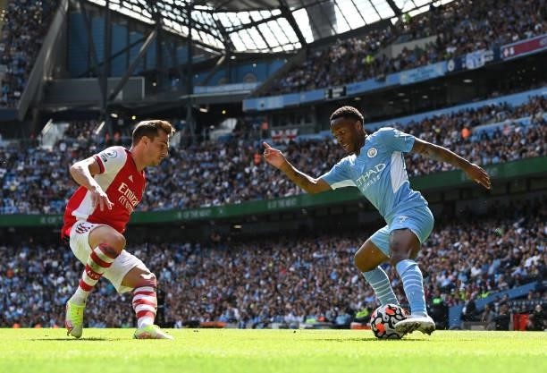 Raheem Sterling of Manchester City controls the ball as Cedric Soares of Arsenal looks on during the Premier League match between Manchester City and...