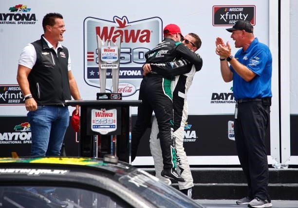 Allmendinger, driver of the Hyperice Chevrolet, hugs Justin Haley, driver of the LeafFilter Gutter Protection Chevrolet, as Matt Kaulig, owner of...