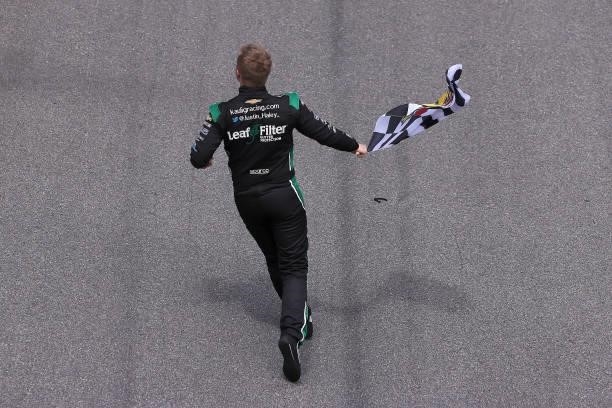 Justin Haley, driver of the LeafFilter Gutter Protection Chevrolet, celebrates with the checkered flag after winning the NASCAR Xfinity Series Wawa...