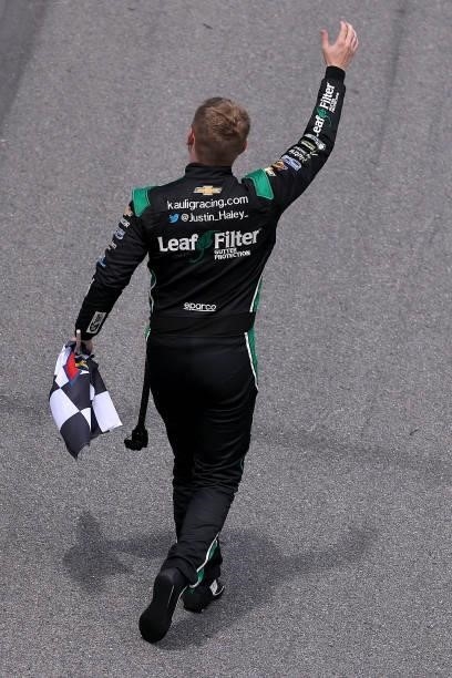 Justin Haley, driver of the LeafFilter Gutter Protection Chevrolet, waves to fans after winning the NASCAR Xfinity Series Wawa 250 at Daytona...