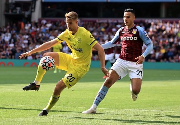 Kristoffer Ajer of Brentford controls the ball watched by Anwar El Ghazi during the Premier League match between Aston Villa and Brentford at Villa...