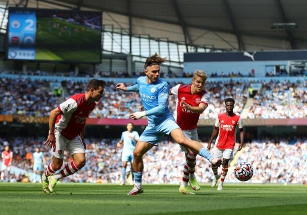 Jack Grealish of Manchester City and Martin Odegaard compete for the ball during the Premier League match between Manchester City and Arsenal at...
