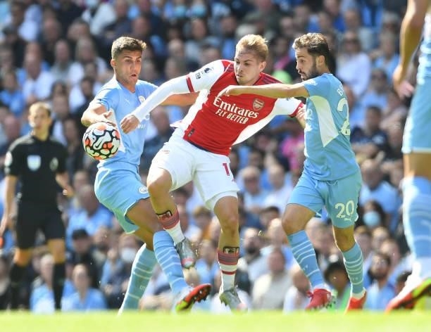 Emile Smith Rowe of Arsenal challenged by Rodri and Bernando Silva of Man City during the Premier League match between Manchester City and Arsenal at...