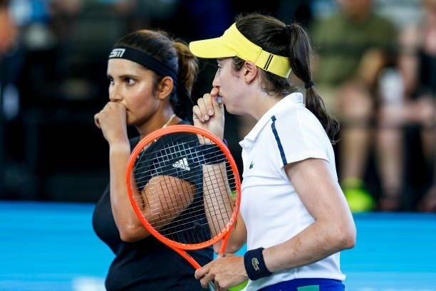 Christina McHale of USA whispers to Sania Mirza of India during the first set of their finals doubles match against Ena Shibahara of Japan and Shuko...