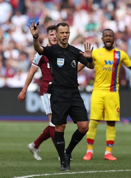 Referee Stuart Attwell gestures during the Premier League match between West Ham United and Crystal Palace at London Stadium on August 28, 2021 in...