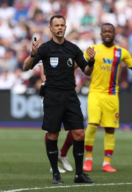 Referee Stuart Attwell gestures during the Premier League match between West Ham United and Crystal Palace at London Stadium on August 28, 2021 in...