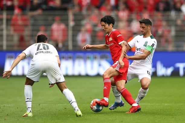 Genki Haraguchi of 1.FC Union Berlin battles for possession with Lars Stindl of Borussia Moenchengladbach during the Bundesliga match between 1. FC...