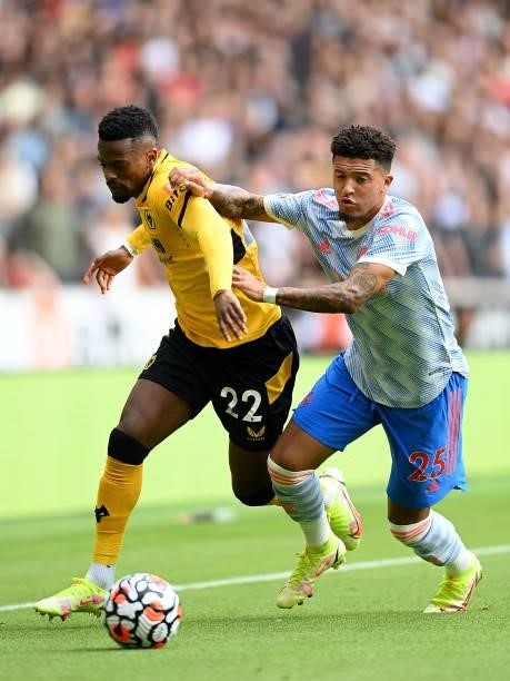 Nelson Semedo of Wolverhampton Wanderers battles for possession with Jadon Sancho of Manchester United during the Premier League match between...