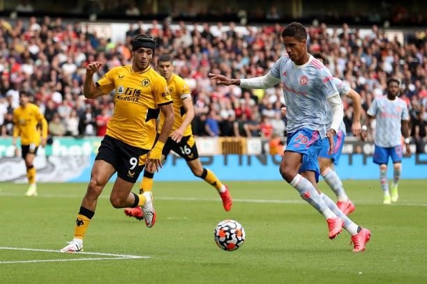 Raul Jimenez of Wolverhampton Wanderers battles for possession with Raphaël Varane of Manchester United during the Premier League match between...