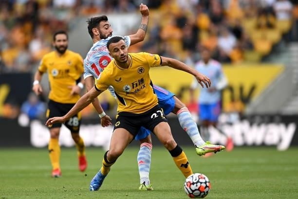 Romain Saiss of Wolverhampton Wanderers battles for possession with Bruno Fernandes of Manchester United during the Premier League match between...